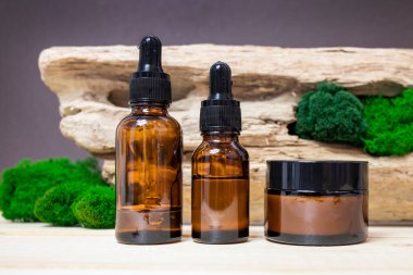 Doğal malzemelerin arka planında cam damlalar ve krema kavanozu var. Naturopati ya da homeopati kavramı..