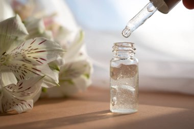 İçinde nemlendirici losyon ya da yüz serumu olan cam damlası şişesi. Yan görünüm.