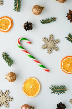 Noel kompozisyonu. Beyaz arka planda noel süsleri ve çizgili baston şekerler. Dikey resim, düz yatış.