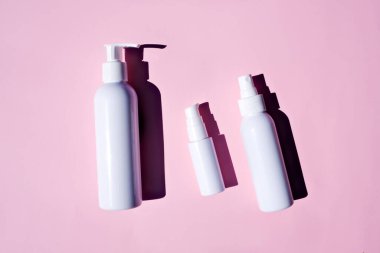 Krem, losyon, jöle, yüz köpüğü veya cilt bakımı. Kozmetik güzellik ürünü markalaşma modeli. Pembe arka planda kozmetik için boş tüpler. Düz yatıyordu.