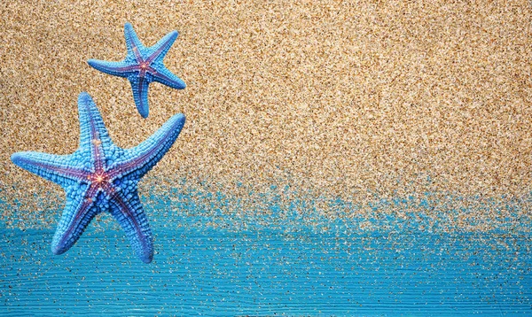 Kleurrijke Zeesterren Natuurlijk Zand Een Blauwe Houten Achtergrond Natuurlijke Textuur — Stockfoto