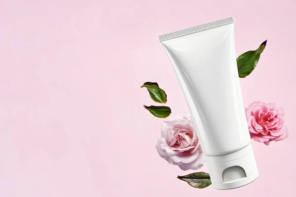 Tube Cosmétique Blanc Vide Sur Fond Rose Avec Délicates Roses — Photo