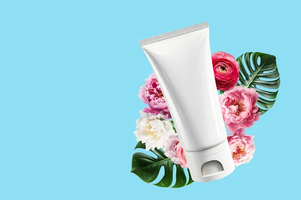 stock image Mock-up of a white plastic bottle for cosmetic skin care products and natural rosebuds on a blue background.