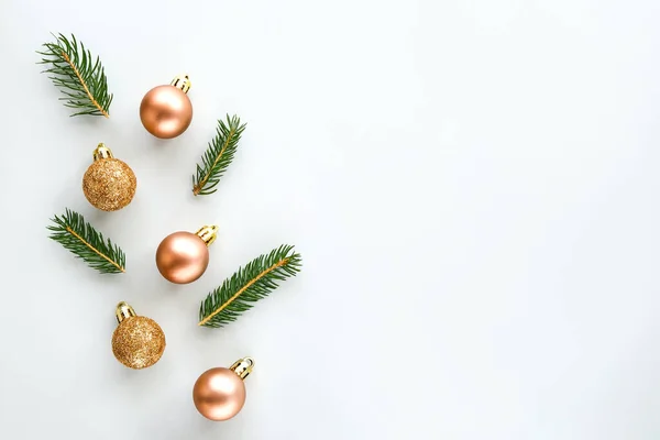 Christmas composition. Christmas glitter balls and natural spruce branches on gray background. Flat lay.