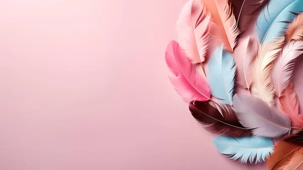 Colorful feathers on a light pink background. Flat lay, top view, copy space.