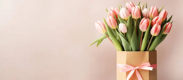 Pastel arka planda hediye paketinde bir buket lale. Pankart, yan görünüm, metin için boşluk.
