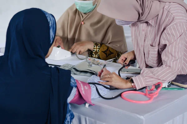 Stock image healthcare, hospital and medicine concept - doctor and patient measuring blood pressure. Sapuran - Wonosobo, Central Java, Indonesia. March 04, 2023.