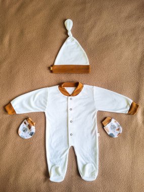 Bebek geçmişi. Beyaz masadaki yeni doğan çocuk için giysi ve aksesuarlar..