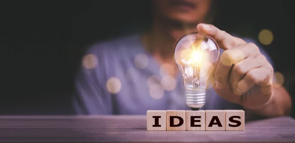 用文字意念触摸木块上的灯泡 用创新和灵感接触新概念 用科学和传播概念接触创新技术 — 图库照片