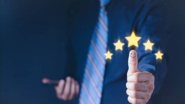 Müşteri memnuniyeti kavramı. El ve başparmak yukarı olumlu duygu gülen yüz ikonu ve kopyalama alanı olan beş yıldız