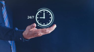  Durmaksızın hizmet kavramı. İş adamı, dünya çapında aralıksız ve hizmet kavramının tam zamanlı teması için 7 / 24 sanal olarak elinde tutuyor. Müşteri hizmetleri.