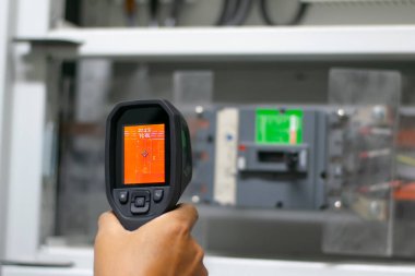 Profesyonel elektrikçi koruyucu bakım, endüstriyel termografi, elektrik enerjisinin termal görüntüsü için termometre veya termometre kullanır..