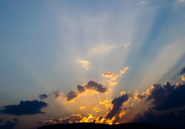 Bir güneş ışığı dağları delip geçer ve mavi gökyüzündeki bulutlar, umudun büyümesi ve başlangıcı.