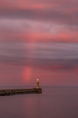İngiltere 'nin kuzeydoğusundaki Tynemouth' da canlı bir gökkuşağı belirdiğinde dramatik bir günbatımı bulutlu gökyüzünü aydınlatıyor.