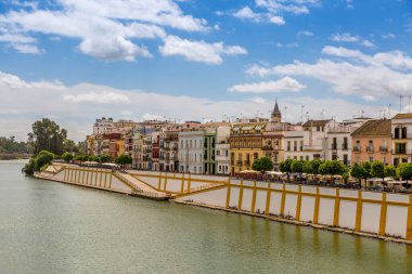 Alfonso Kanalı boyunca (Alfonso Kanalı XIII) Triana ilçesine ve Sevilla, İspanya 'daki ünlü renkli Calle Betis ilçesine (Betis Caddesi' ne tercüme edilir) doğru uzanır.