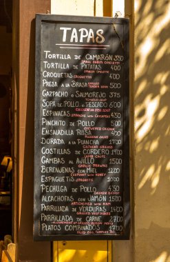 İspanya, Seville 'de bir restoranın önünde tahtaya beyaz tebeşirle yazılmış geleneksel bir tapas menüsü.