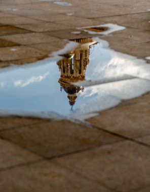 Şiddetli yağmurun ardından Sevilla 'nın binaları yağmur suyu birikintilerine yansımaktadır. Burada Seville Katedrali 'nin su birikintisine yansıyan kuleleri var.