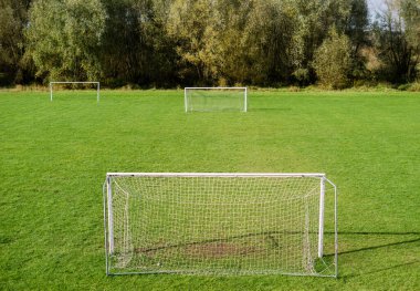 Kale direkleri ve yeşil çimleri olan boş bir futbol sahası, futbol antrenmanı sahası