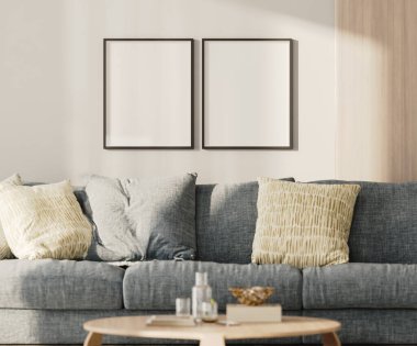 Lobide iki boş çerçeve, mavi kanepe ve duvarında ahşap pano olan bir masa.