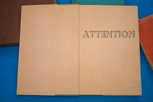 Attention word in opened book with vintage, natural patterns old antique paper design.