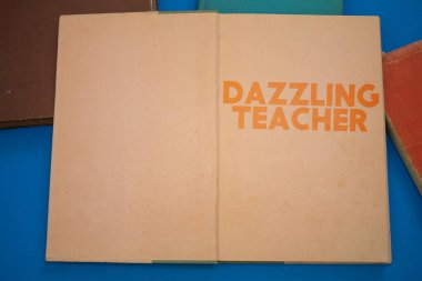 Eski antika kağıt tasarımı ile klasik, doğal desenli açık bir kitaptaki göz kamaştırıcı Öğretmen kelimesi.