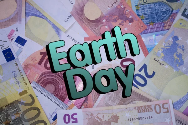 Earth Day word with money. Paper currency background with different banknotes.