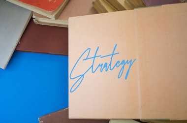 Klasik, doğal desenli, antika kağıt tasarımlı, açık bir kitaptaki strateji kelimesi..