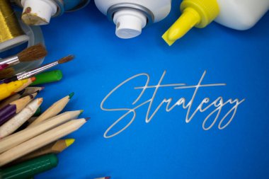 Strateji metniyle okul malzemelerinin üstten çekimi. Fırçalar, kalemler, sanatsal aletler. Sanat ve Sanatsal Çalışma Aletleri.