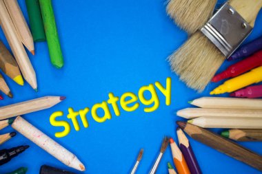 Strateji metniyle okul malzemelerinin üstten çekimi. Fırçalar, kalemler, sanatsal aletler. Sanat ve Sanatsal Çalışma Aletleri.