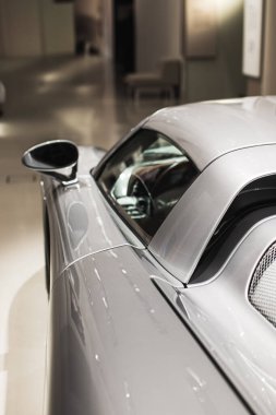 Parlak gümüş renkli Porsche Carrera GT detayı. Aerodinamik çizgilere, yan girişlere ve parlak bitiş çizgilerine odaklan. Lüks ve yüksek performansı temsil eder.