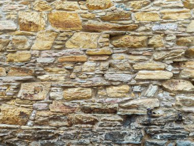 Kum tonlarında üst üste binen taşlar duvarı