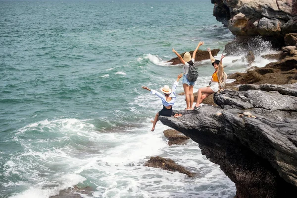 여행을 즐기는 여성들의 그룹은 바다에 절벽으로 여행하는 순간을 즐긴다 — 스톡 사진
