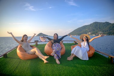 Bir grup turist yaz tatilinin tadını çıkarıyorlar. Birlikte tekneyle deniz kenarında akşam yemeği için seyahat ediyorlar.