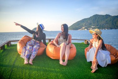 Bir grup turist yaz tatilinin tadını çıkarıyorlar. Birlikte tekneyle deniz kenarında akşam yemeği için seyahat ediyorlar.
