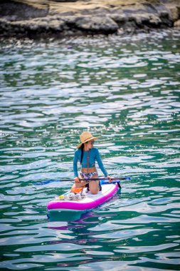 Denizde kürek çeken bir kadın. Yaz tatili. Hafta sonu adaya seyahat.