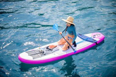 Denizde kürek çeken bir kadın. Yaz tatili. Hafta sonu adaya seyahat.