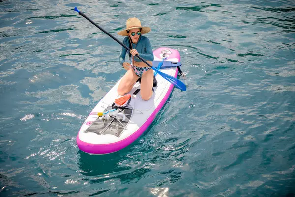 Denizde kürek çeken bir kadın. Yaz tatili. Hafta sonu adaya seyahat.