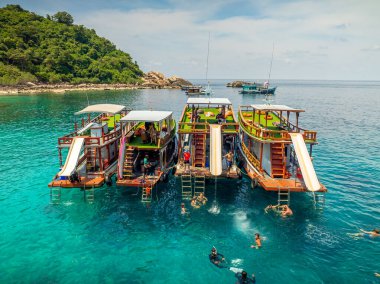 Doğal körfezin üst hava manzarası tonlarca gezgin turist alıyor. Tur tekneleri iniyor. İnsanlar yaz tatilinde birlikte su sporunun tadını çıkarıyorlar.