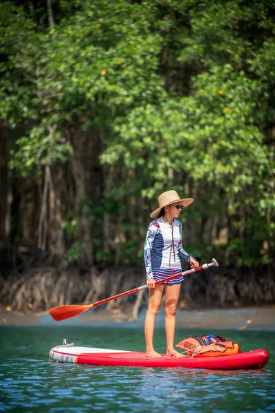 Kadınlar yağmur ormanlarının doğal göl nehrinde ayakta kürek çekmeyi severler.