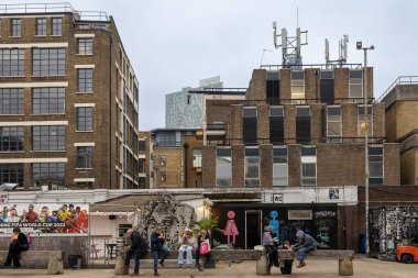 Londra, Uk - 17 Aralık 2022, İnsanlar kaldırımda otururken sokak yemekleri yiyorlar. Brick Lane alanı.
