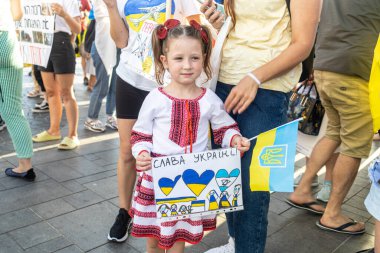 Tel Aviv, İsrail - 20 Mart 2022, Ukrayna 'daki Rus saldırısını protesto. Ukrayna ulusal giysili küçük bir kız üzerinde Ukrayna 'nın İhtişamı yazan bir poster taşıyor.