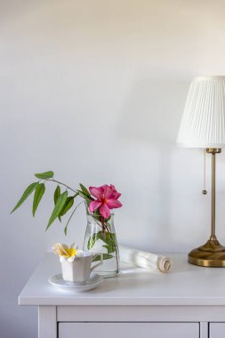 Kahve fincanında pipo rumba, vazoda okaliptüs dalı ve beyaz bir masada iki çerçeveli bir duvara karşı bir fincan kahve. Yerleşim planı hazır. Dikey çerçeve. Metin için boşluk