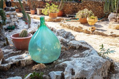 Bahçe dekorasyonunun bir parçası olarak büyük yeşil bir şişe.