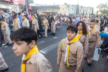 Hayfa, İsrail - 17 Aralık 2022: St. Elias Piskoposluk Okulu öğrencileri Alman Kolonisi 'ndeki Noel geçit törenine katıldılar. İzleyiciler geçidi izliyor