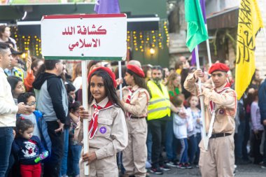 Hayfa, İsrail - 17 Aralık 2022: St. Elias Piskoposluk Okulu öğrencileri Alman Kolonisi 'ndeki Noel geçit törenine katıldılar. İzleyiciler geçidi izliyor