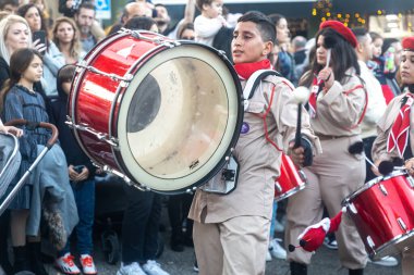 Hayfa, İsrail - 17 Aralık 2022: St. Elias Piskoposluk Okulu öğrencileri Alman Kolonisi 'ndeki Noel geçit törenine katıldılar. İzleyiciler geçidi izliyor