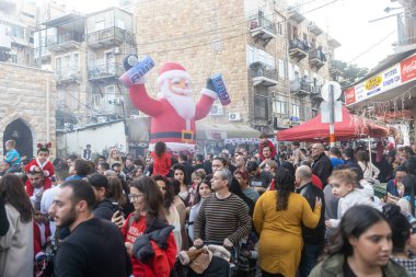 Hayfa, İsrail - 17 Aralık 2022: St. Elias Piskoposluk Okulu öğrencileri Alman Kolonisi 'ndeki Noel geçit törenine katıldılar. İzleyiciler geçidi izliyor
