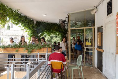 Hayfa, İsrail - 14, 2022, İnsanlar Talpiot pazarının yanındaki kafede yemek yiyor