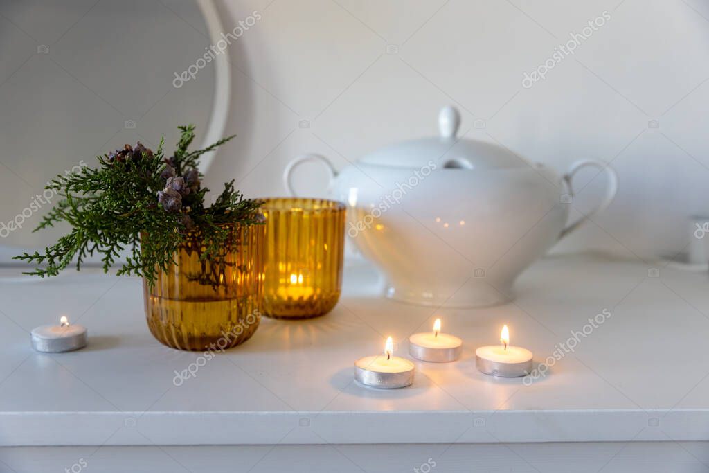 Candelabros de cristal amarillo, una rama de arborvitae con conos, una