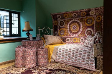 30 Kasım 2022, Liberty 's, Lüks Mağazası. İçinde bir yatak, kırmızı bir yatak örtüsü, yastıklar ve yeşil duvarda bir halı..